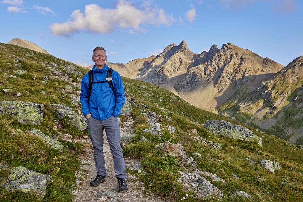 John Bragg portrait depicting solo travel while on a hike in the Swiss Alps.