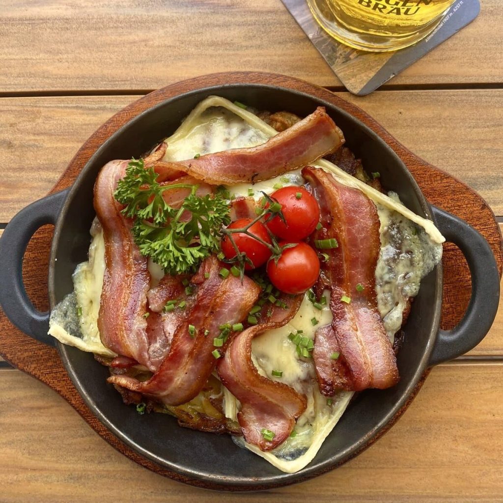 One of the best things to do in Lauterbrunnen is to enjoy Rösti, an authentic Swiss dish featuring grated potatoes with Raclette cheese and crispy bacon strips