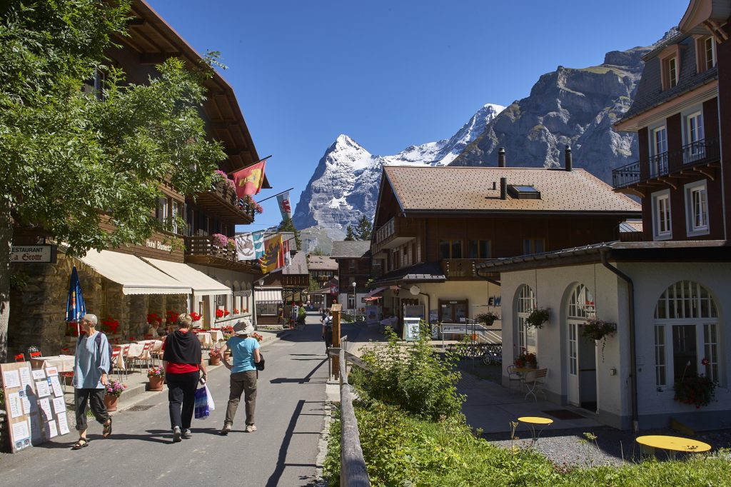 The main road in the town of Mürren, Switzerland with a view of the Swiss alps in the background