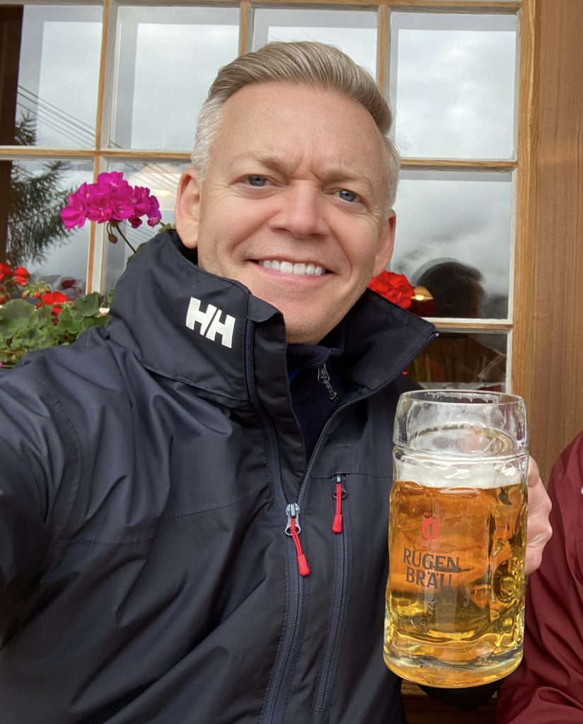 Smiling man while holding a liter of Rugenbräu beer in Mürren, Switzerland